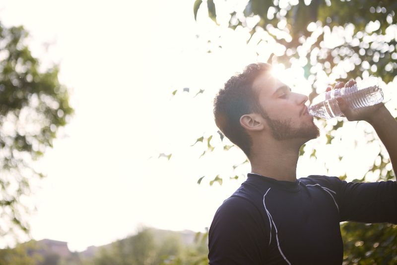 man drinking water to recover after workout