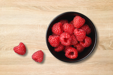 Rasperries, one in the list of high fiber foods, in a bow and set on the table.