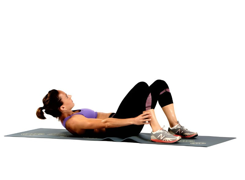 An image of a woman doing ankle grab exercise.