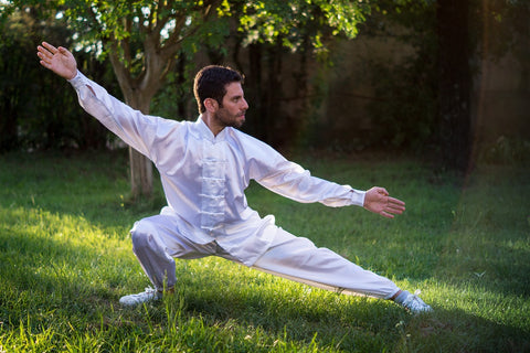 An image of a man doing tai chi, one of the grounding techniques to bring calmness into life.