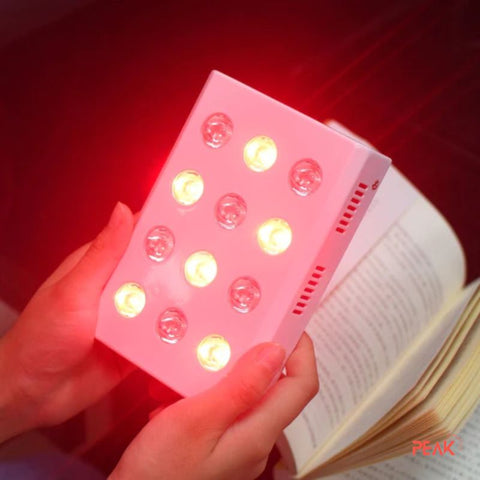 a person holding a snall red light device