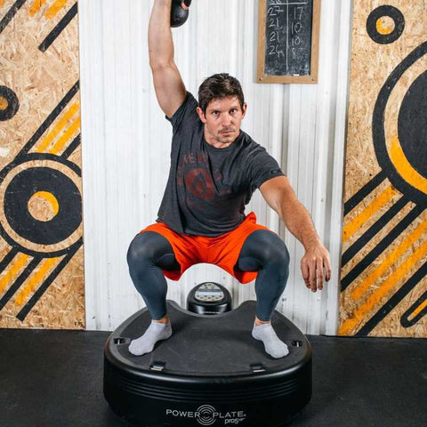 a man lifting weights on top of a power plate