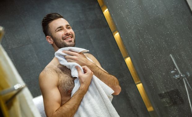 Smiling man drying himself with a towel