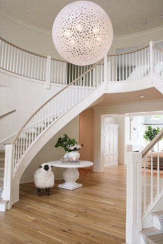 Staircase foyer with chandelier, table, and sheep
