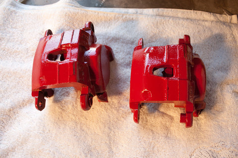 Red painted brake calipers being cleaned