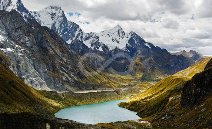 alpine lake and snow-capped andes mountains on cloudy day