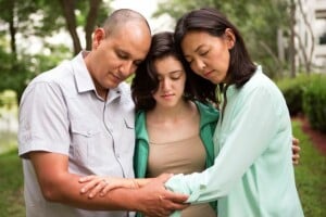 three family members consoling each other