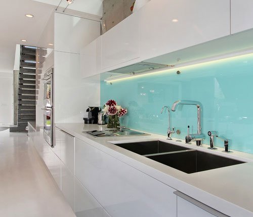 kitchen counter with light blue glass backsplash