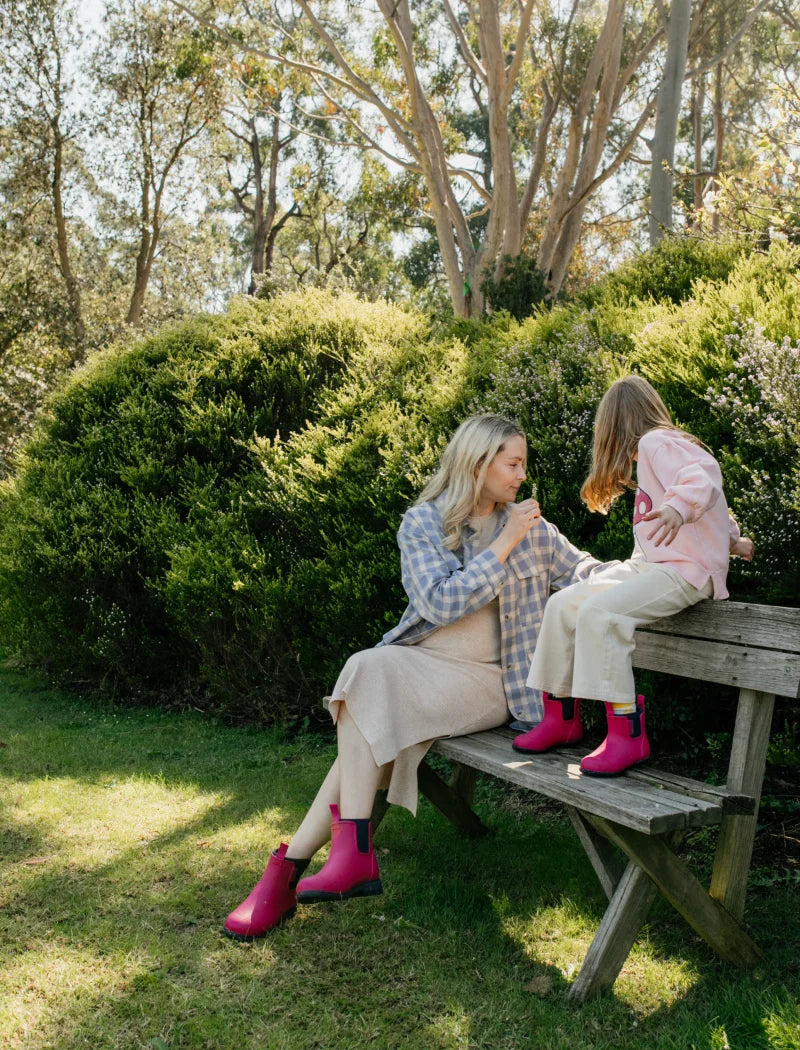 mother and daughter enjoying time in the park wearing magenta boots