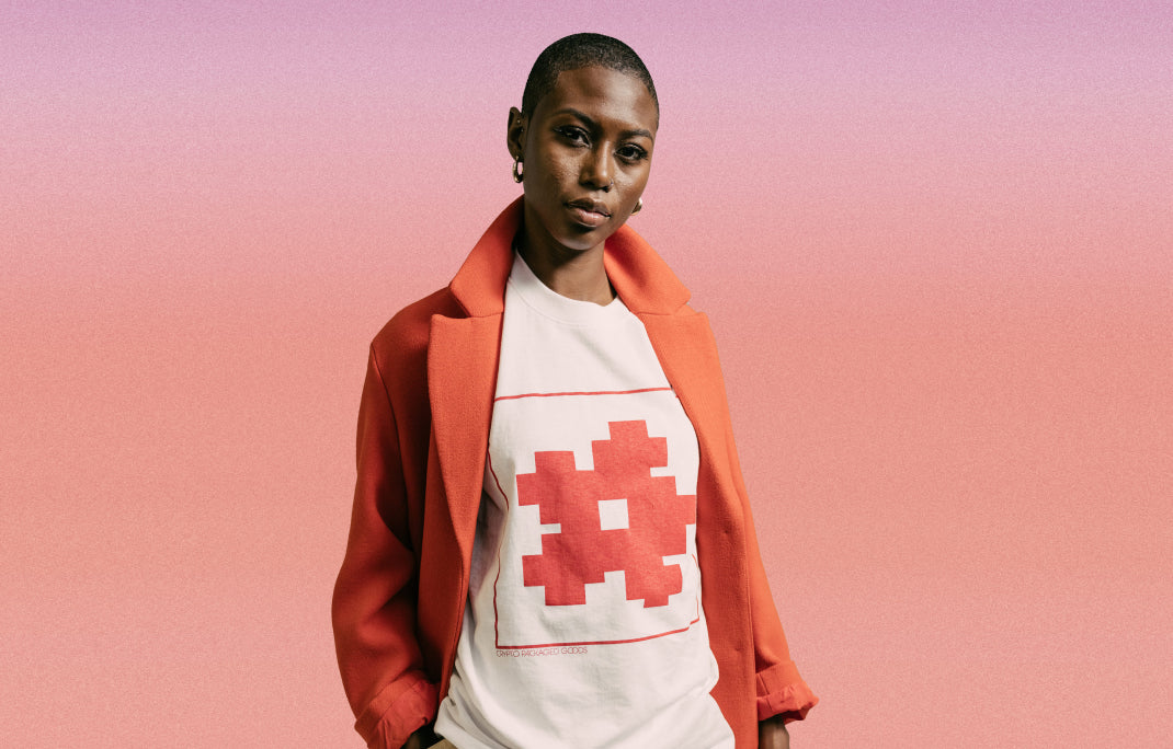 A Black female model with short natural hair wearing the Flower Token Tee from CPG’s Fall/Winter 2023 collection