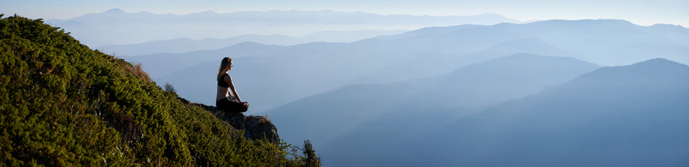 meditating-female-is-relaxing-mountains