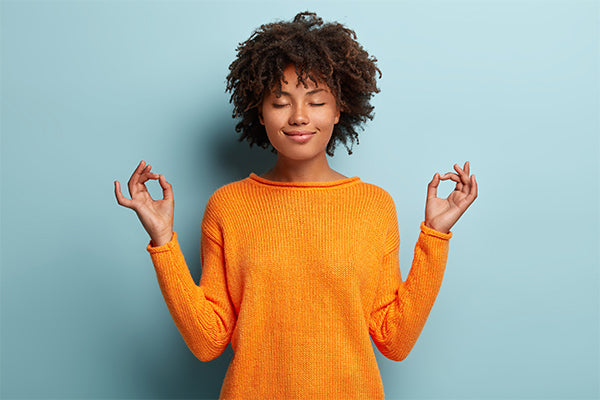 mindful-peaceful-afro-american-woman-meditates-indoor-keeps-hands-mudra-gesture-has-eyes-closed