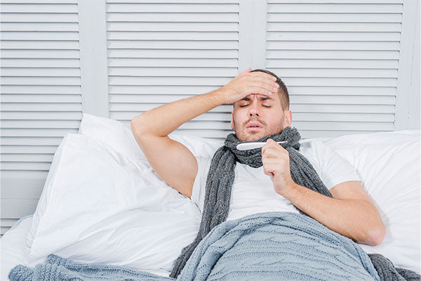 common-cold-and-flu-symptoms-man-checking-temperature-in-bed