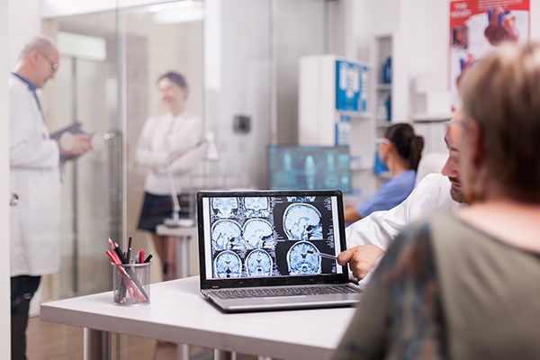 MND-Motor-Neurone-Disease-eldery-woman-looking-at-her-brain-scan-with-doctor