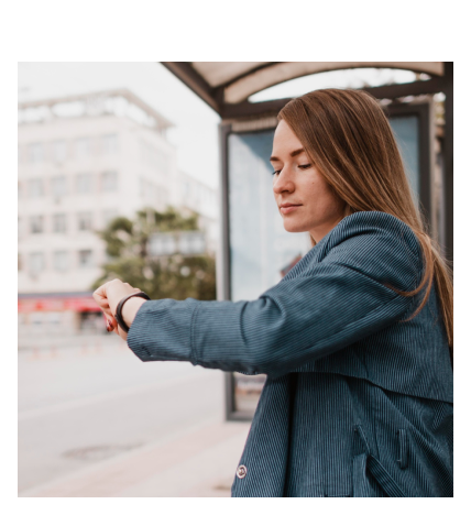 Woman checking the time on her watch at a bus stop.