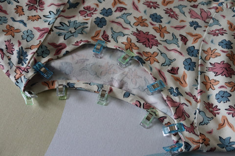 Rolled bias binding around neckline, held by clips before stitching in.