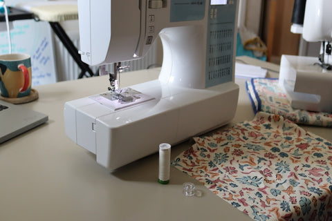 Sewing Machine on the table with a thread, side panels cut out of fabric ready to sew