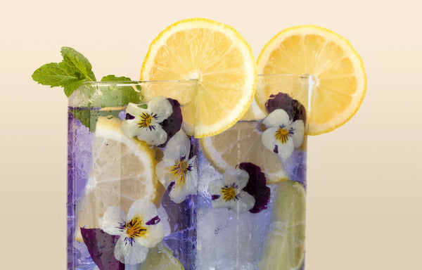 Fresh pansies in a purple drink.