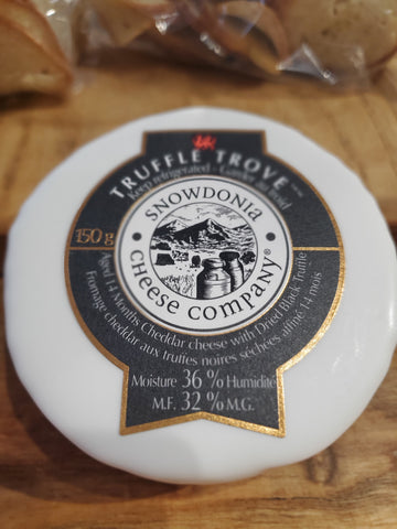 A small wheel of Aged Cheddar with Truffle coated in white wax. 