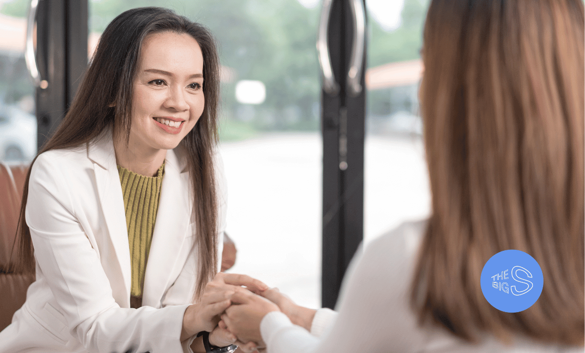 a doctor holds the hand of a person in a supportive way listening and making direct eye contact