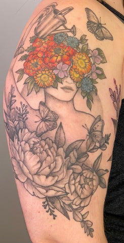 image of a tattoo on an arm - females figure with flowers and nature