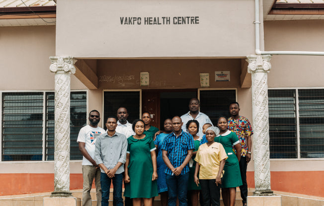 Alt: Medical staff gathered outside Vakpo Health Center in Ghana