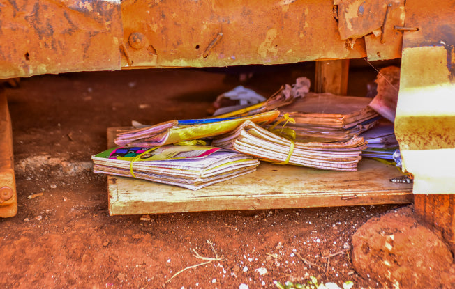 Alt: School books on a dirty natural floor