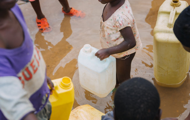 Alt: African children with plastic containers to collect water