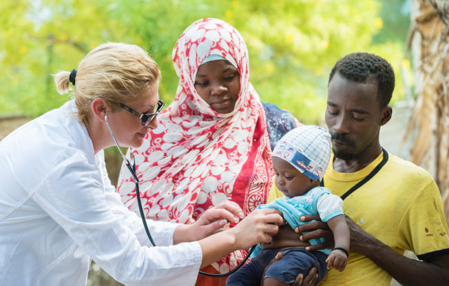 Alt: A female doctor works to improve child health in Africa by tending to a baby