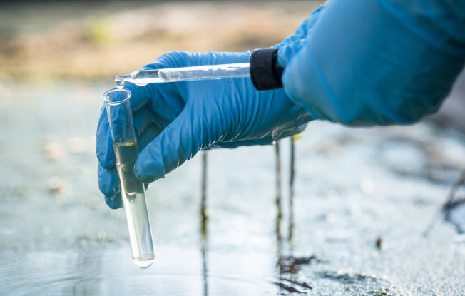 Alt: A scientist tests the water quality to help combat water pollution in Africa