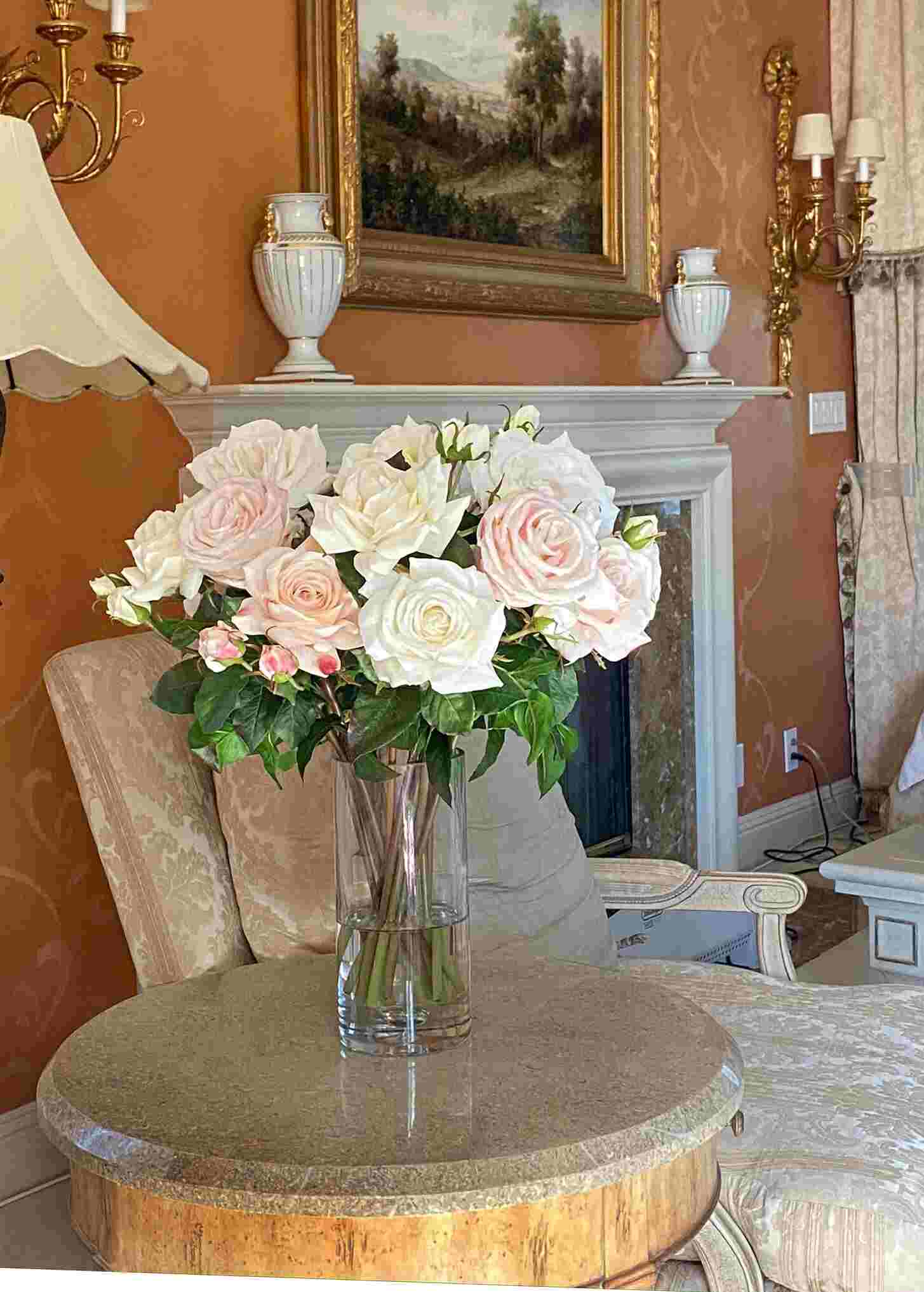 Faux rose arrangement in glass cylinder on side table