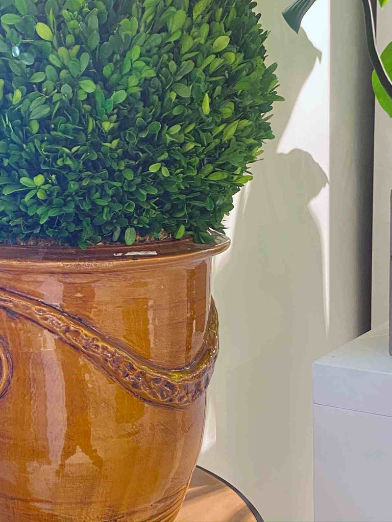 Faux boxwood in pot used as indoor decor