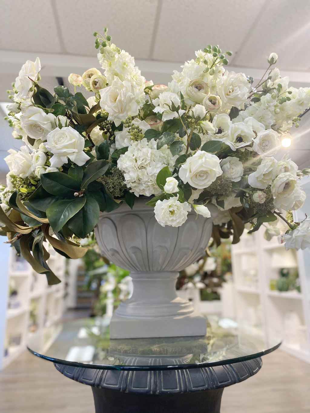 Faux centerpiece arrangement with white hydrangeas, roses, and greenery