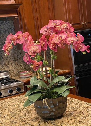 Faux phalaenopsis pink orchid display in bowl on kitchen counter