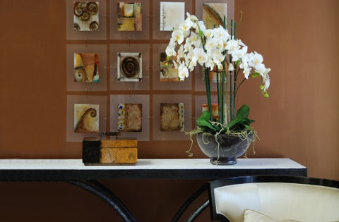 Faux phalaenopsis white orchid display in black bowl on table