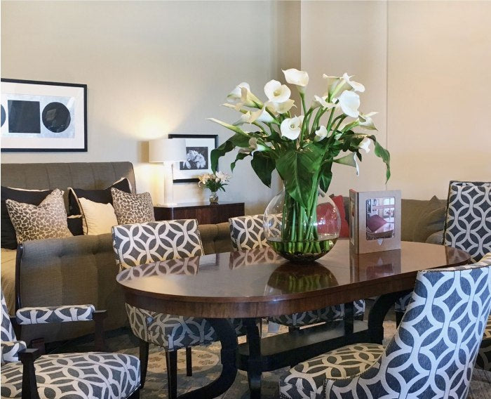 Faux flowers in a vase on a dining room table