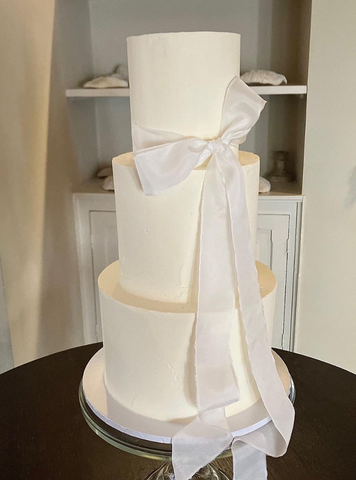 Three tiered buttercream iced cake and silk bow