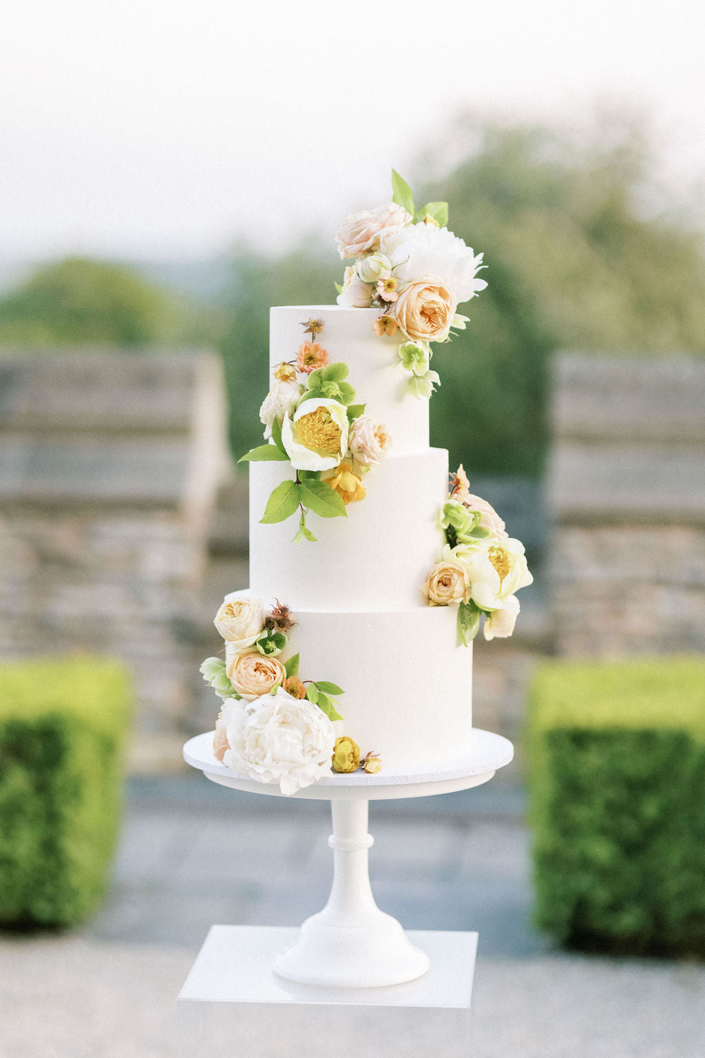 Three tiered white buttercream wedding cake by the Vanilla Pod Bakery at Euridge Manor - Image by Camilla Arnold Photography