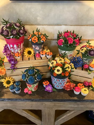 Buttercream flower cupcake display in flower pots on wooden crates