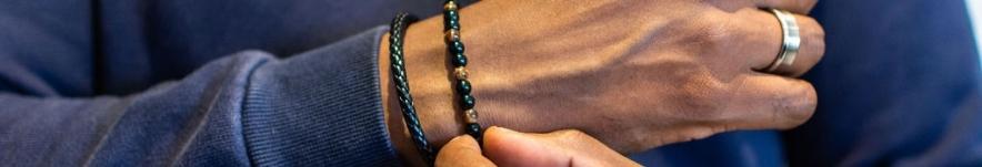 Close up of a man's hand, adjusting bangles around his wrist from James Jewellery.