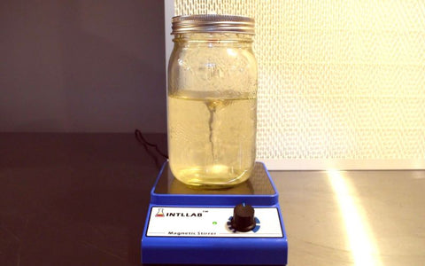 A magnetic stirrer swirling the contents of a liquid culture jar.