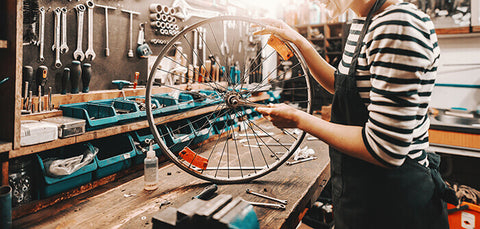 A person fixing a bicycle tire in a bike shop