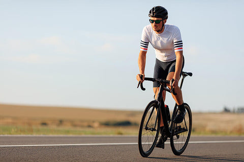 A cyclist riding a bike on a road, demonstrating proper bike handling and control