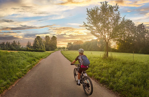 A person riding a bike in nature, enjoying the mental health benefits of cycling