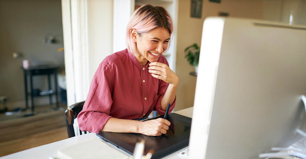 Happy female employee hybrid working at a computer