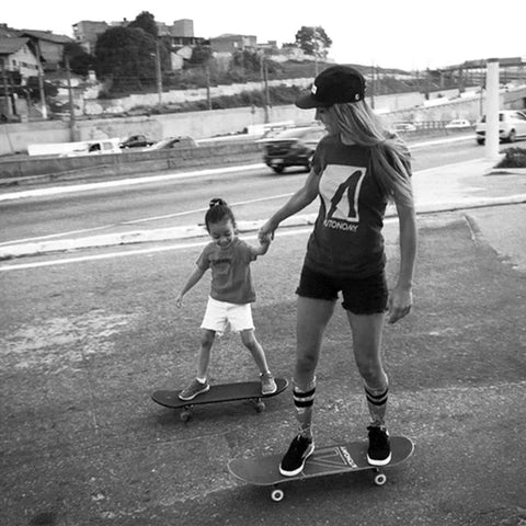 Eliana Sosco riding a skateboard with a little girl