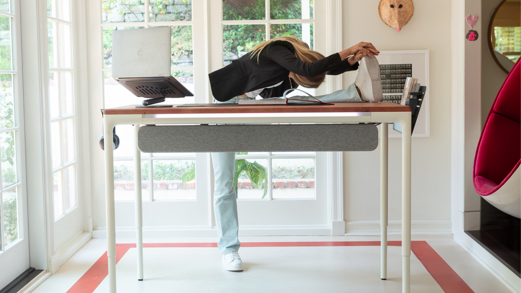 Image of Sarah DeAnna making a yoga position on the Tenon Desk