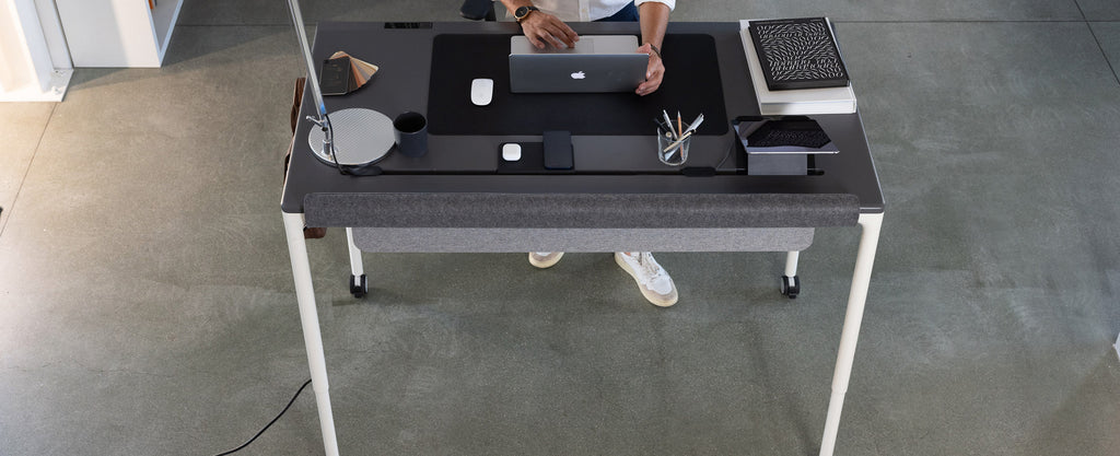 a grey four leg standing desk