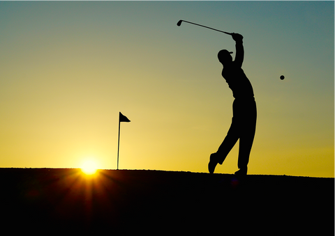 Man golft met zonsondergang
