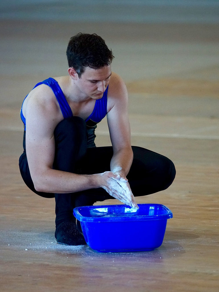 Gymnast met magnesium poeder op zijn handen